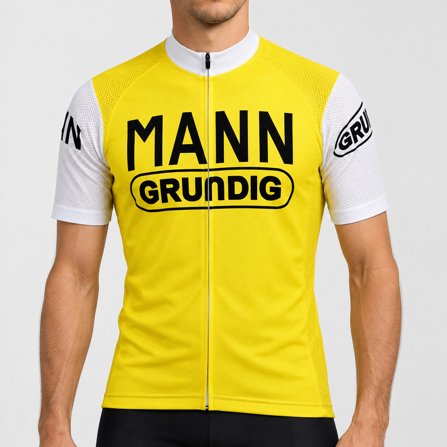 Male model wearing the yellow Dr. Mann Grundig short-sleeve retro cycling jersey with white collar and sleeves and black MANN GRUNDIG lettering, shown from the chin down against a neutral studio background.