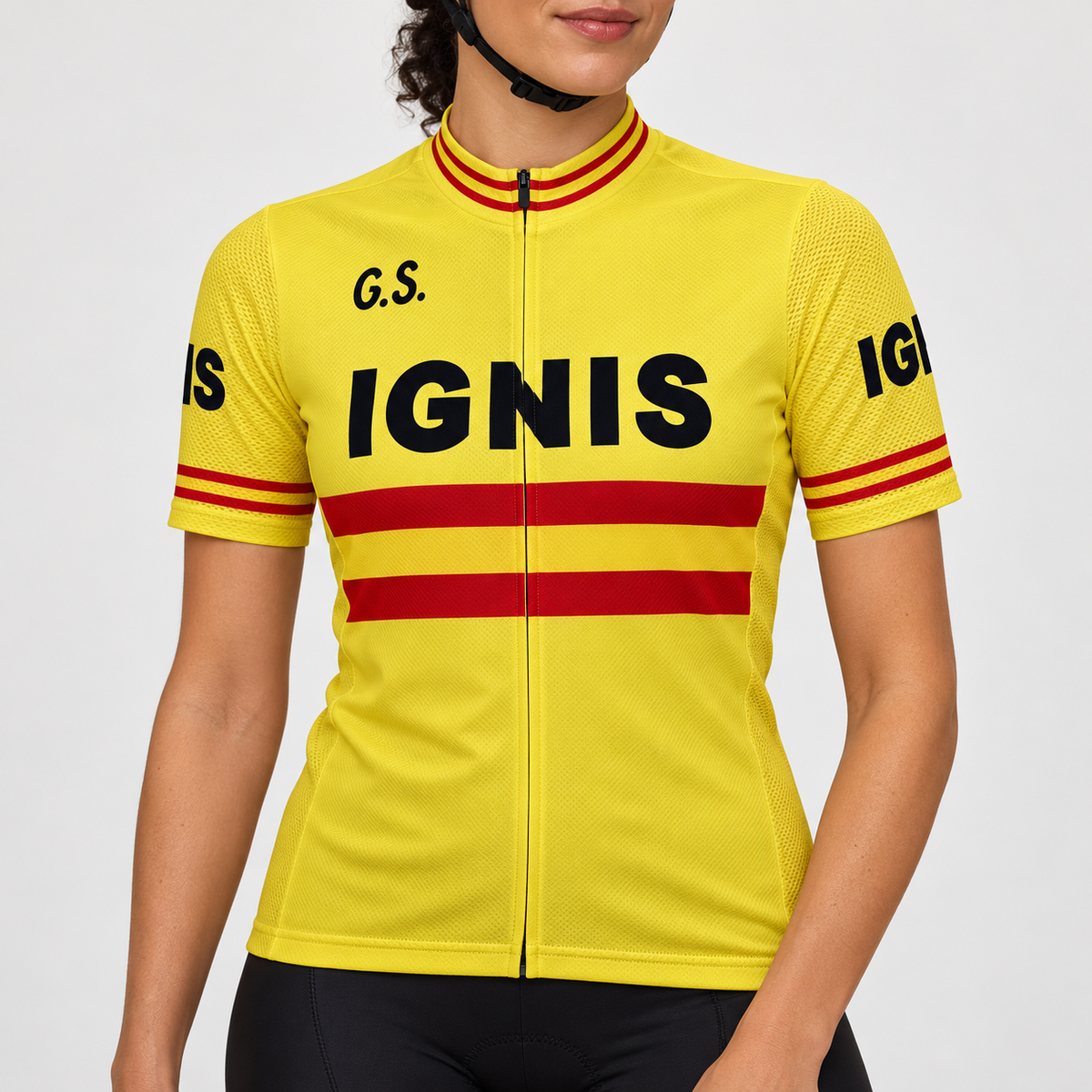 Female model wearing the yellow short-sleeve Retro Ignis cycling jersey with black G.S. and IGNIS lettering, red torso and cuff stripes, and black cycling shorts against a light grey studio background.