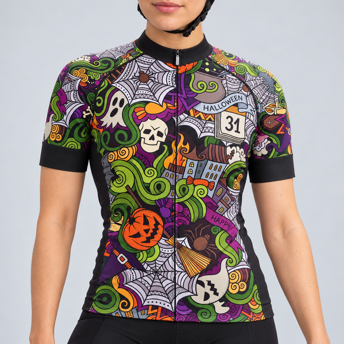 Female model wearing the short-sleeve 31st October Halloween cycling jersey with colourful spooky graphics and black cycling shorts, shown from the lower lip and chin down against a light grey studio background.