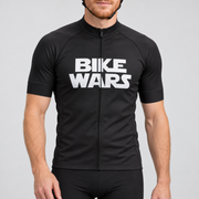 Male model wearing the black short-sleeve Bike Wars cycling jersey with white BIKE WARS lettering and black cycling shorts, shown from the lower lip down against a neutral studio background.