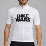 Male model wearing the white short-sleeve Bike Wars cycling jersey with black BIKE WARS lettering and black cycling shorts, shown from the lower lip down against a neutral studio background.