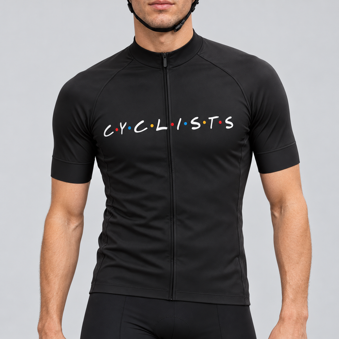 Male model wearing the black short-sleeve C.Y.C.L.I.S.T.S cycling jersey with white chest lettering and coloured dots, shown from the chin down with black cycling shorts against a neutral studio background.