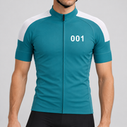 Male model shown from the chin down wearing the teal Squid Character 001 short-sleeve cycling jersey with white shoulder panels and white 001 chest number against a light grey studio background.