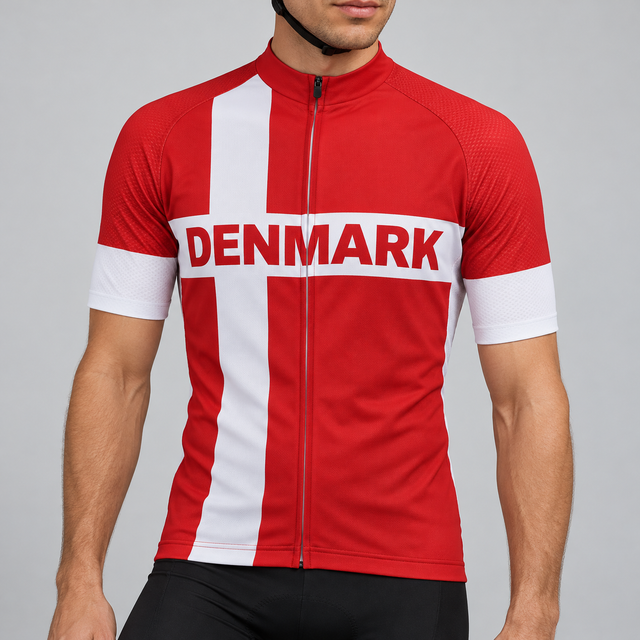 Male model wearing the red and white short-sleeve Denmark Flag cycling jersey with DENMARK lettering and black cycling shorts, shown from the chin down against a neutral studio background.