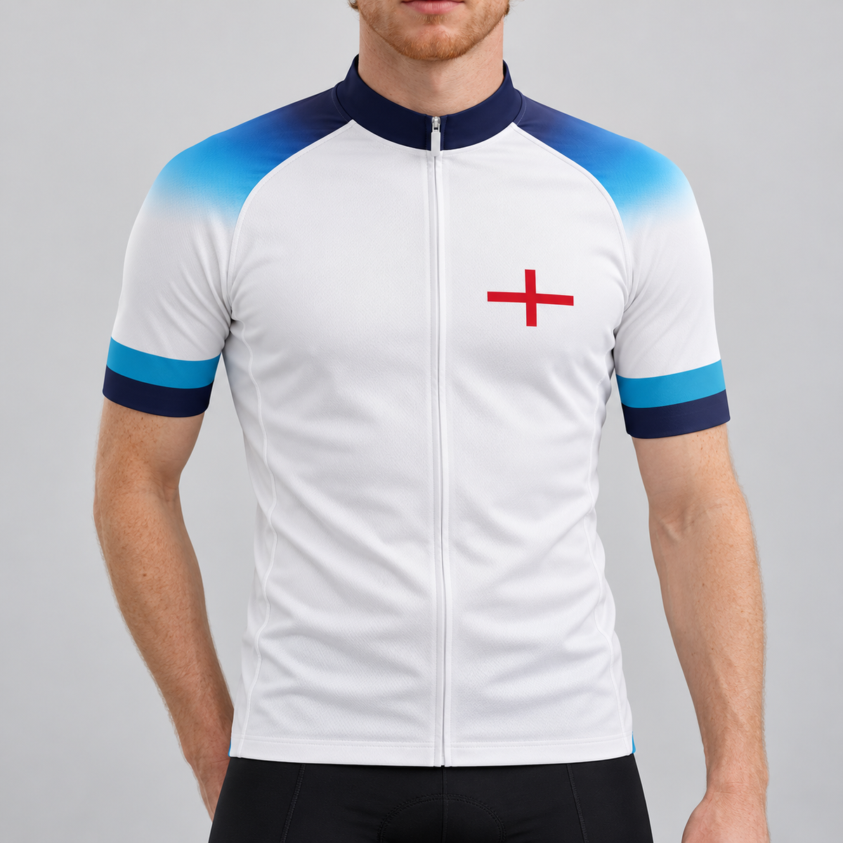 Male model wearing the white England 2022 football-inspired short-sleeve cycling jersey with blue gradient shoulders, navy and turquoise cuffs and a red St George cross, shown from the chin down against a neutral studio background.