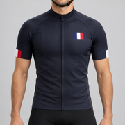 Male model wearing the dark navy short-sleeve France 2022 Football Inspired cycling jersey with French tricolour chest and cuff details, shown from the chin down with black cycling shorts against a neutral studio background.