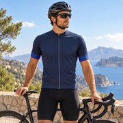 Male cyclist wearing the GG BASICS Blue With Light Blue Sleeve Cycling Jersey outdoors