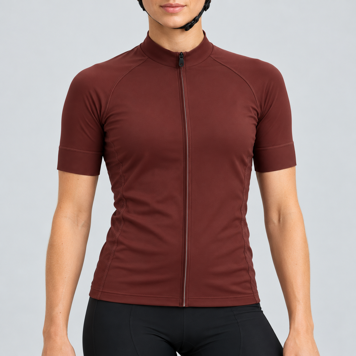 Female model wearing the plain burgundy short-sleeve GG BASICS cycling jersey with matching collar, cuffs and mesh side panels, shown with black cycling shorts against a light grey studio background.