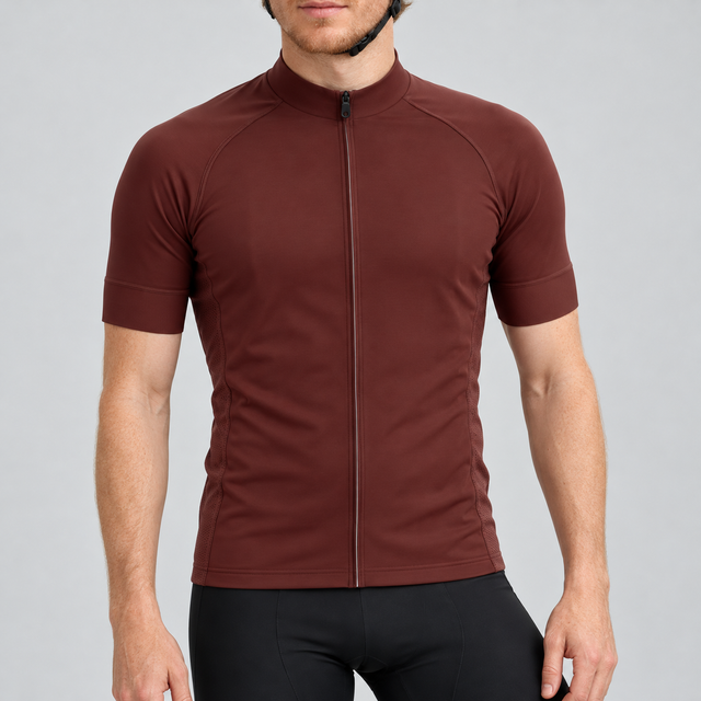 Male model wearing the plain burgundy short-sleeve GG BASICS cycling jersey with matching collar and cuffs and mesh side panels, shown with black cycling shorts against a light grey studio background.