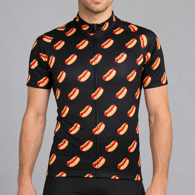 Male model shown from the lower lip down wearing a black short-sleeve cycling jersey with orange and red hot-dog illustrations and yellow mustard against a light grey studio background.