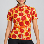 Female model wearing a short-sleeve golden-yellow and red pepperoni pizza-print cycling jersey with black cycling shorts, shown from the mouth down against a light grey studio background.