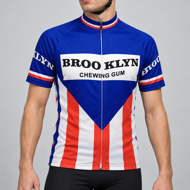 Male model shown from the chin down wearing the blue, red and white Retro Brooklyn short-sleeve cycling jersey with BROO KLYN CHEWING GUM chest lettering against a light grey studio background.