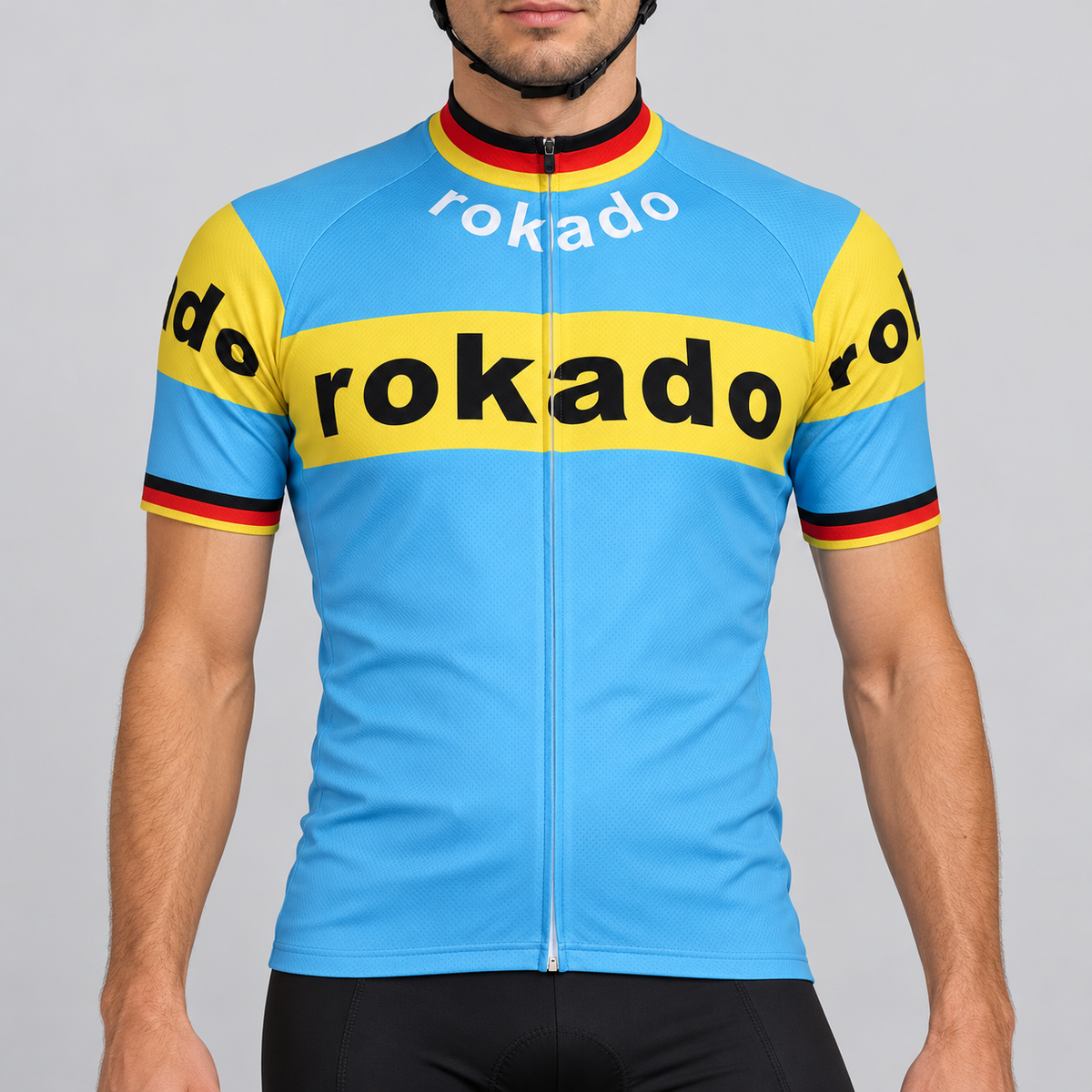 Male model shown from the chin down wearing the sky-blue and yellow Retro Rokado short-sleeve cycling jersey against a light grey studio background.