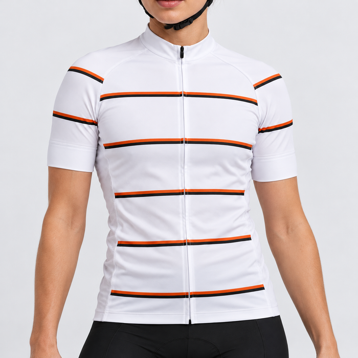 Female model wearing the white short-sleeve GG BASICS White Hoops cycling jersey with orange and black horizontal stripes, shown with black cycling shorts against a light grey studio background.