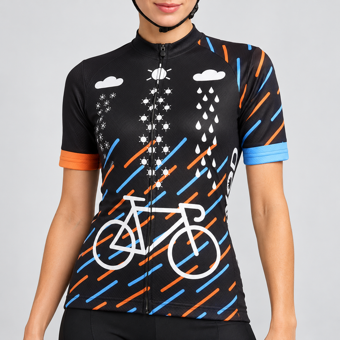 Female model wearing the black short-sleeve Come Rain Or Shine cycling jersey with white bicycle and weather graphics, orange and blue diagonal rain strokes and contrasting cuffs, shown with black cycling shorts against a light grey studio background.